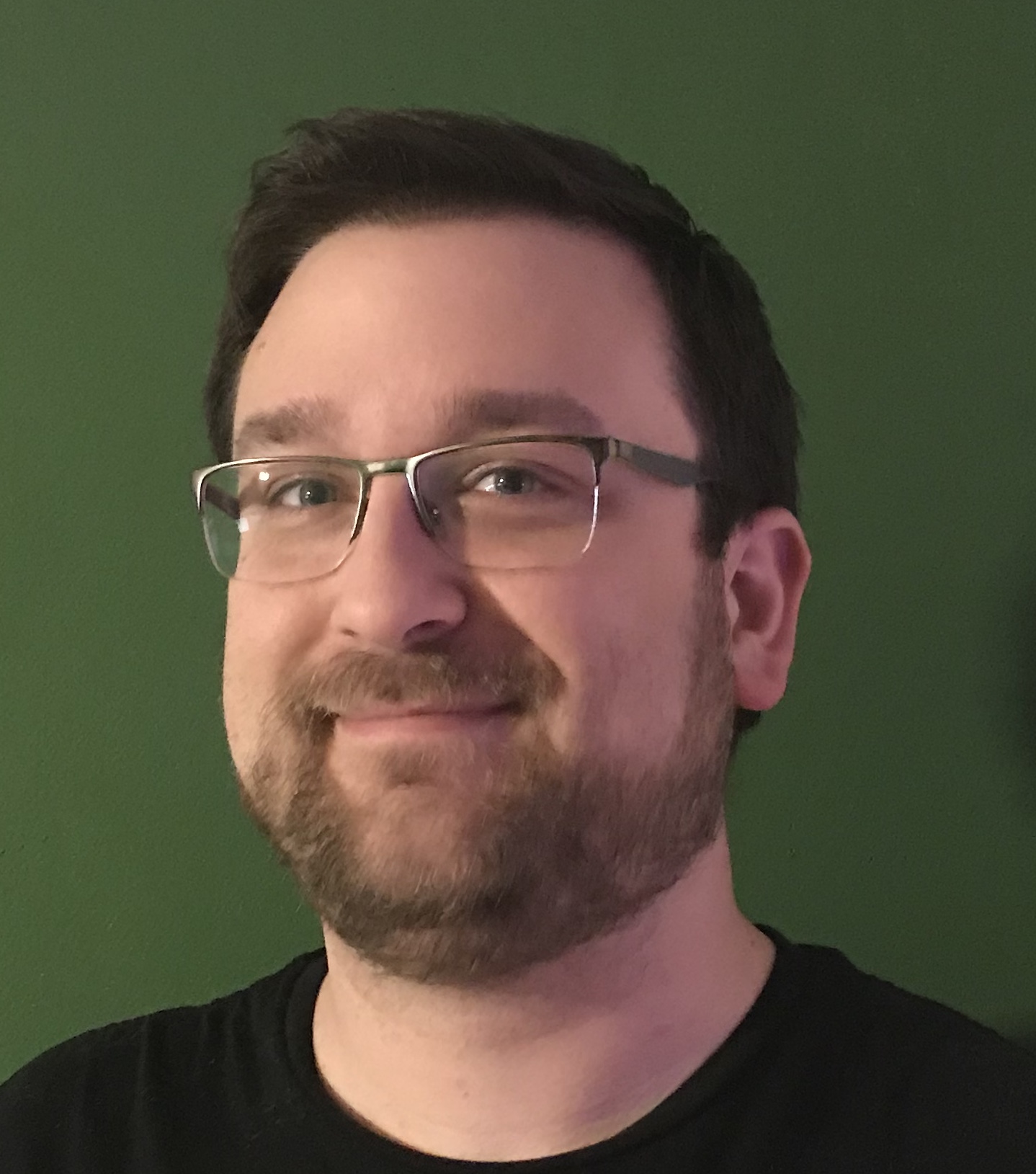 Portrait of Josh Rendek, smiling, wearing glasses